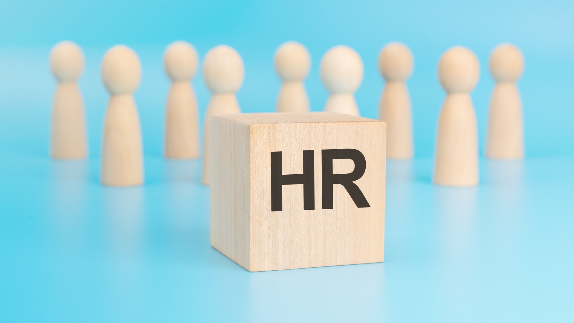 HR - wooden block with letters, human resources new employees HR concept, top view on blue background